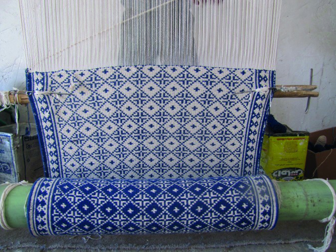 Blue-and-white Iranian cotton zilu on a loom, pattern identified as zolfak topor in the cited research article